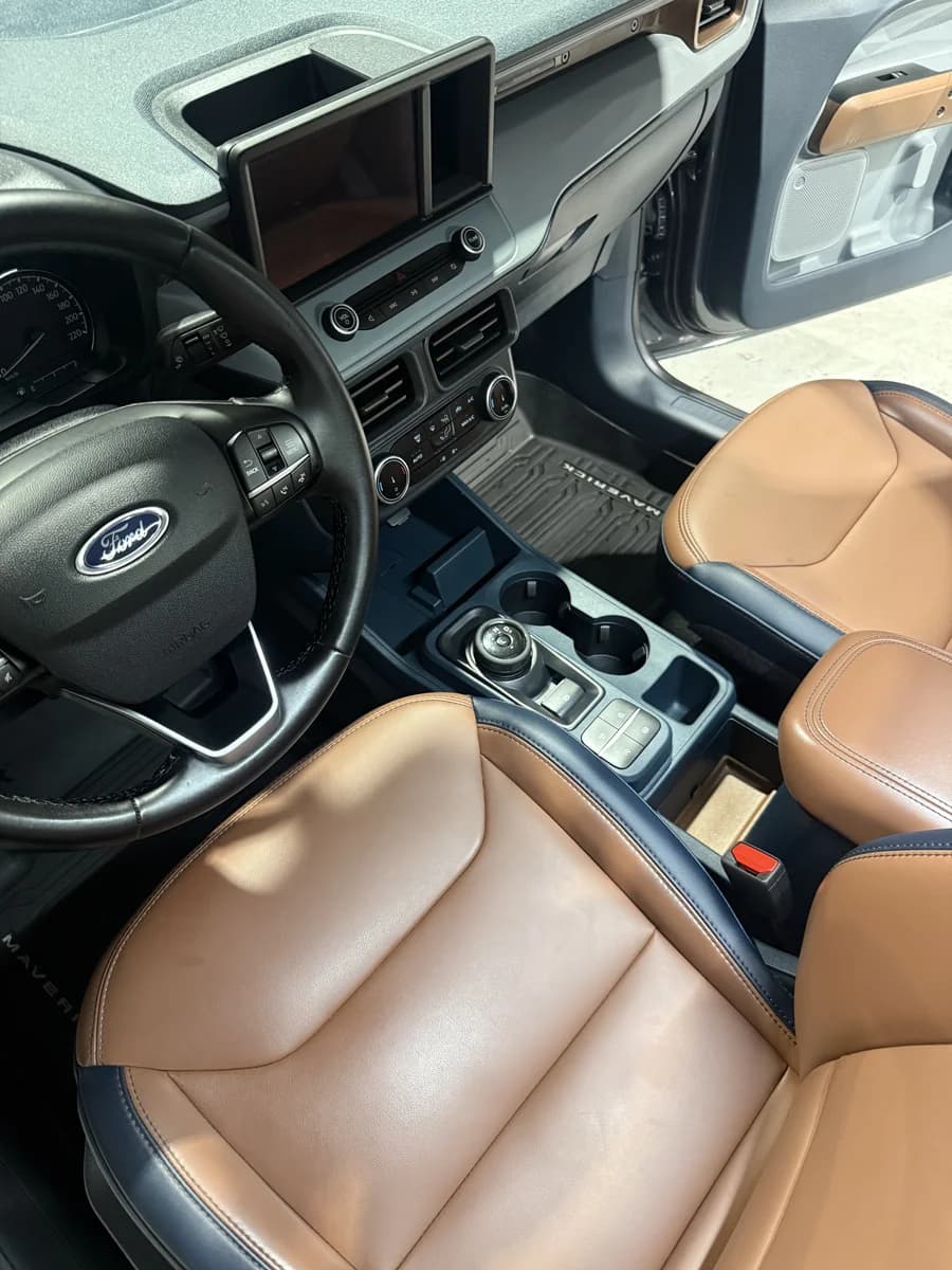 The same Ford Maverick interior after detailing, with clean floor mats, console and leather seats