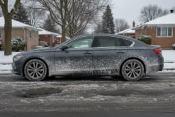 Sedan coated in white road salt spray on a winter Toronto street